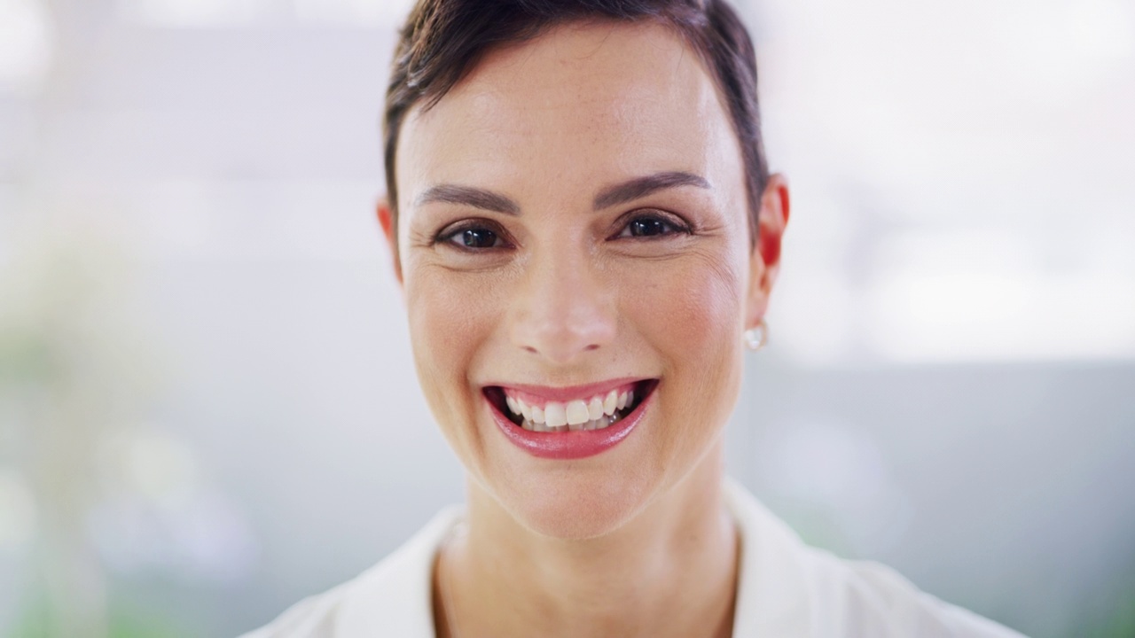 一位美丽的白人女商人的肖像，带着灿烂的微笑站在办公室里。面对一个快乐的企业家，她期待着在她的创业公司获得成功的新机会视频下载