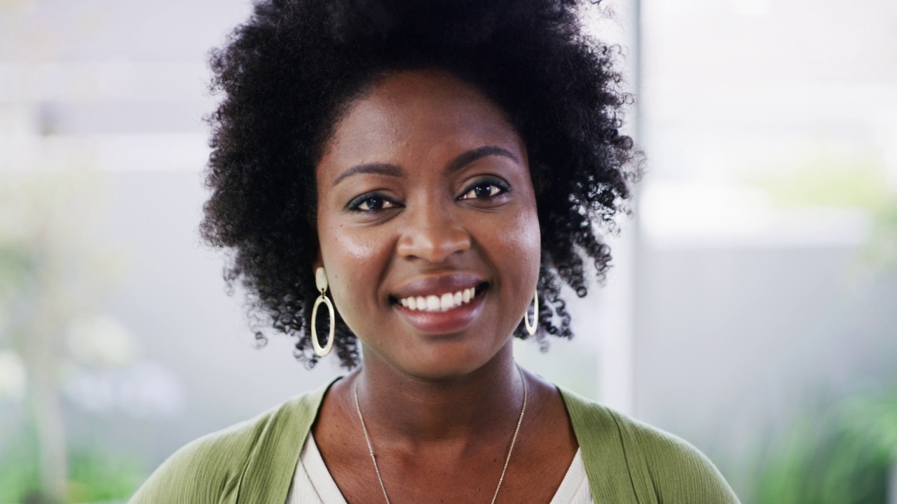 一位自信的非洲裔美国女商人站在办公室微笑的肖像。面对雄心勃勃的企业家和坚定的领导者，微笑着准备在创业机构取得成功视频下载