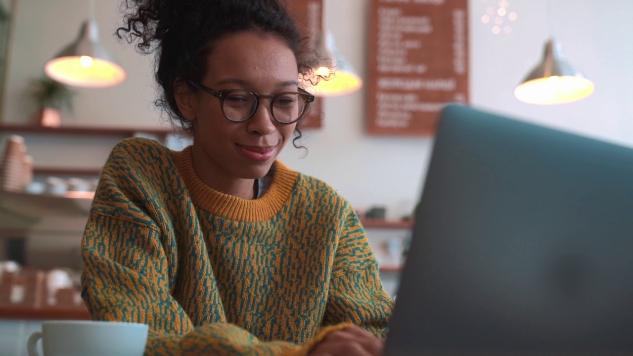 积极的女人在咖啡馆用笔记本电脑工作视频素材
