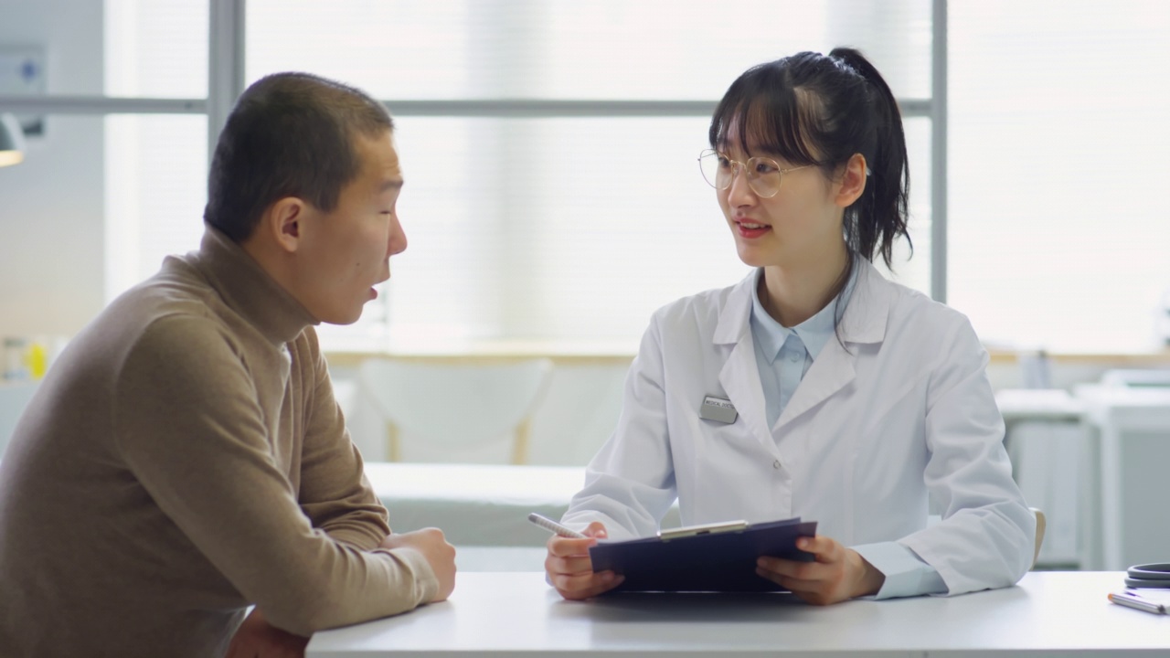 亚洲女医生在医务室给男人提供咨询视频素材