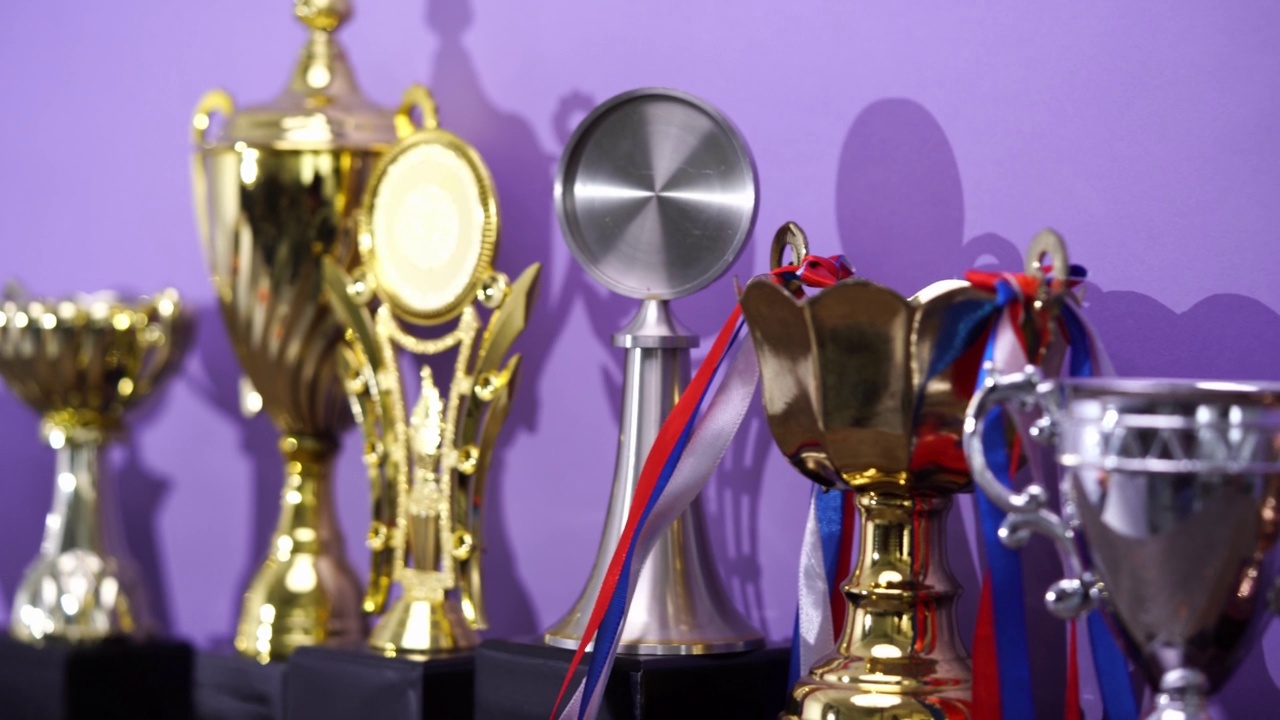 一组奖杯在紫色背景下排成一行视频素材