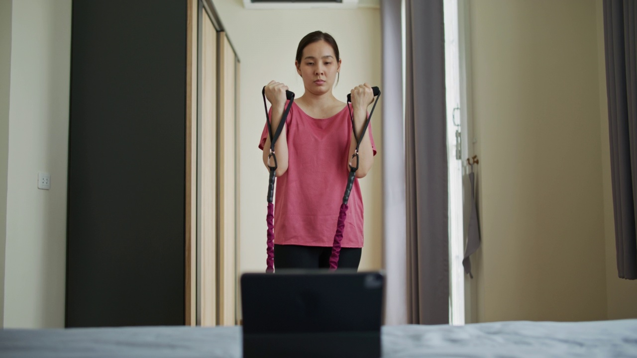 女性在家进行虚拟健身课程视频素材