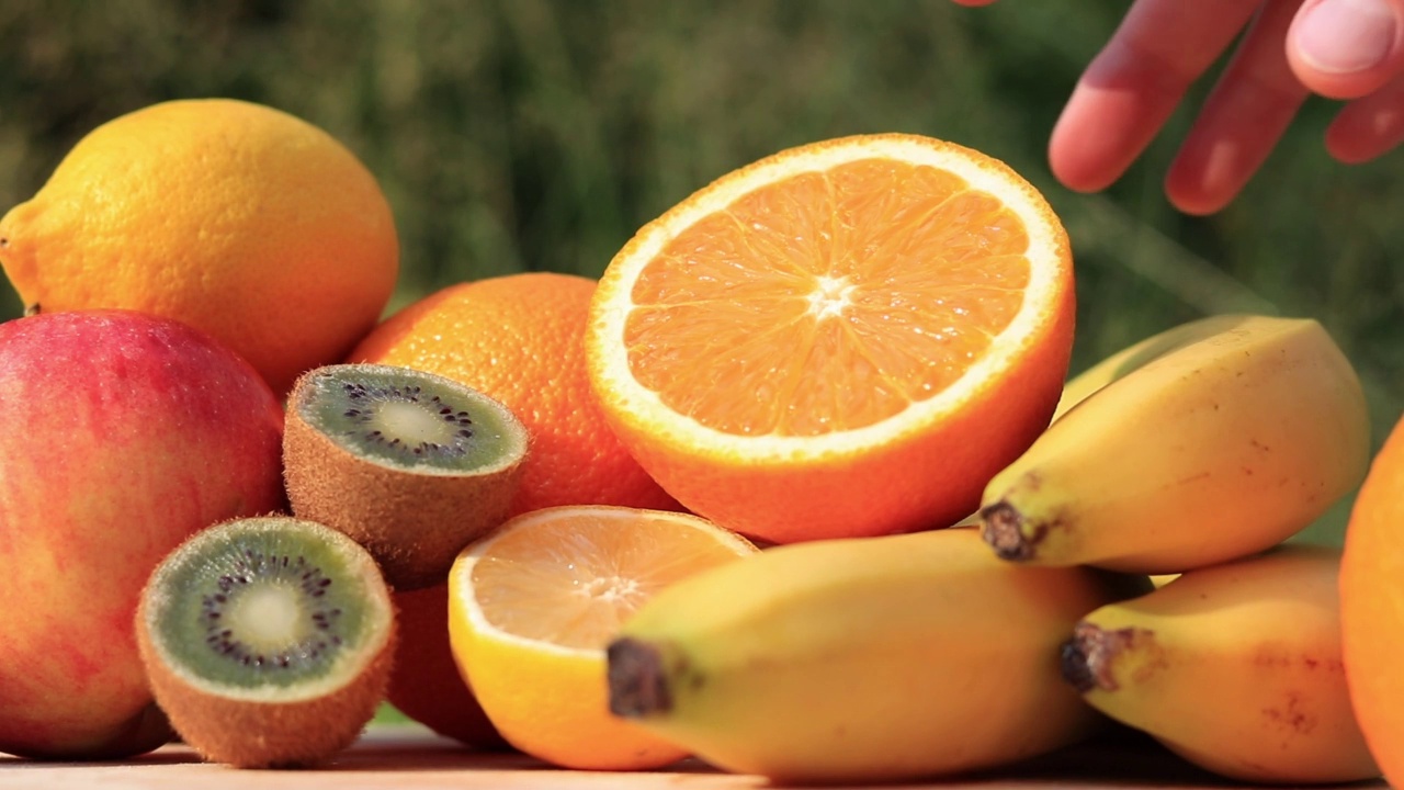 手拿着一个切好的橘子。鲜榨果汁的原料视频下载