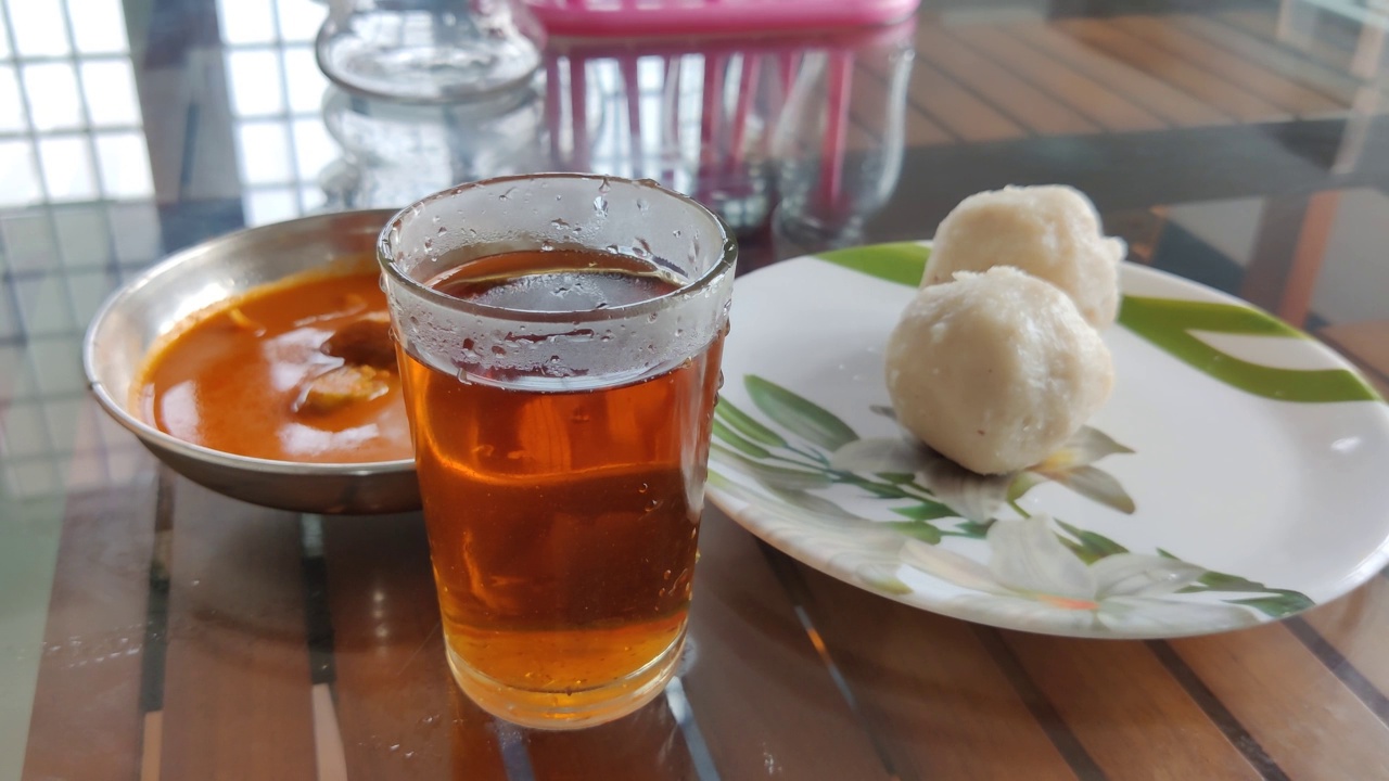 桌上的白色小吃和鱼咖喱旁边放着一杯红茶视频下载