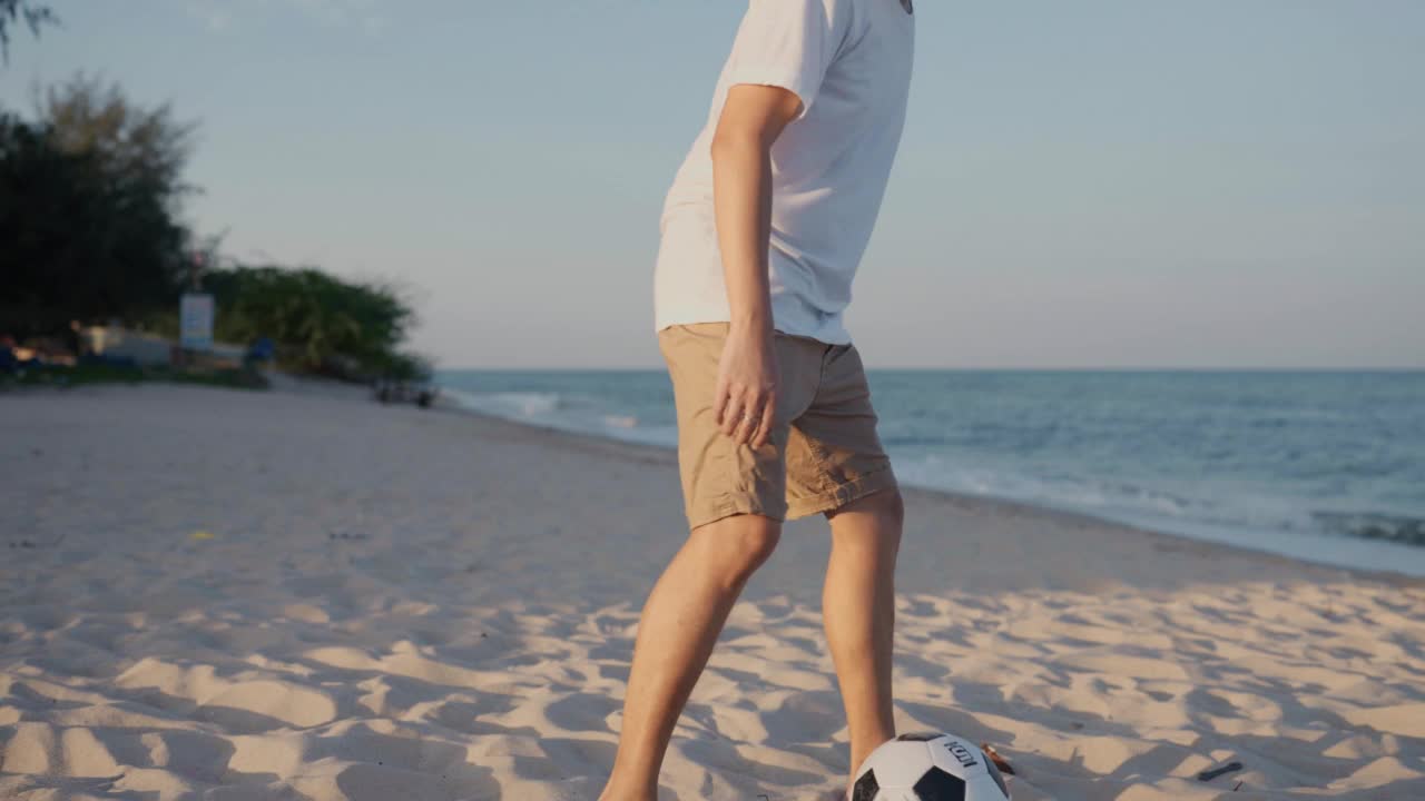 亚洲父亲和他的小儿子在一起踢足球视频素材