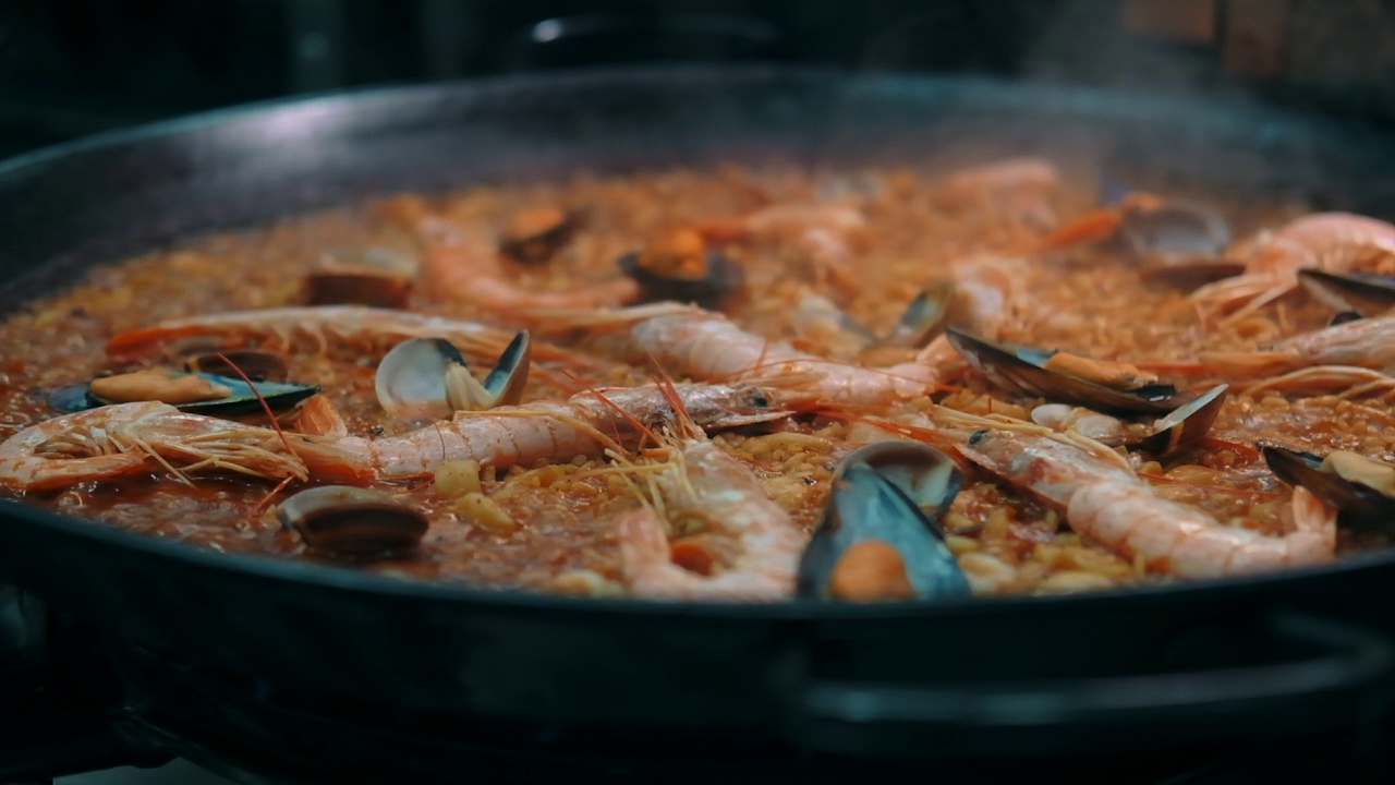 特写慢动作查看海鲜饭在煎锅上烹饪视频素材