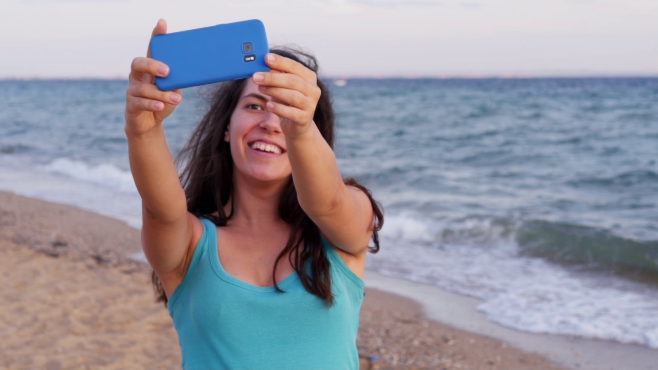 一个女人在海滩上自拍视频素材