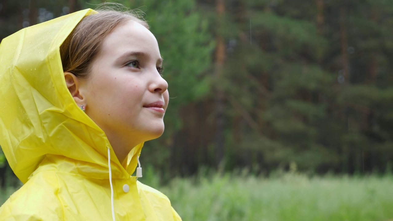 沉思的女孩望向别处，享受森林里的雨天视频素材