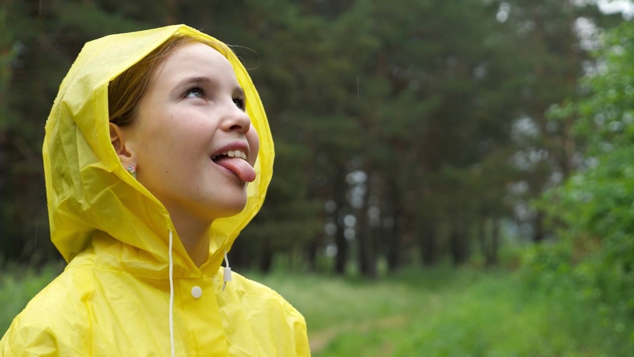 快乐的女孩在雨天伸出舌头去接雨滴视频素材