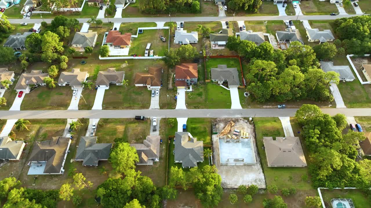 鸟瞰美国小镇的郊区景观与私人住宅之间的绿色棕榈树在佛罗里达州安静的居民区视频素材