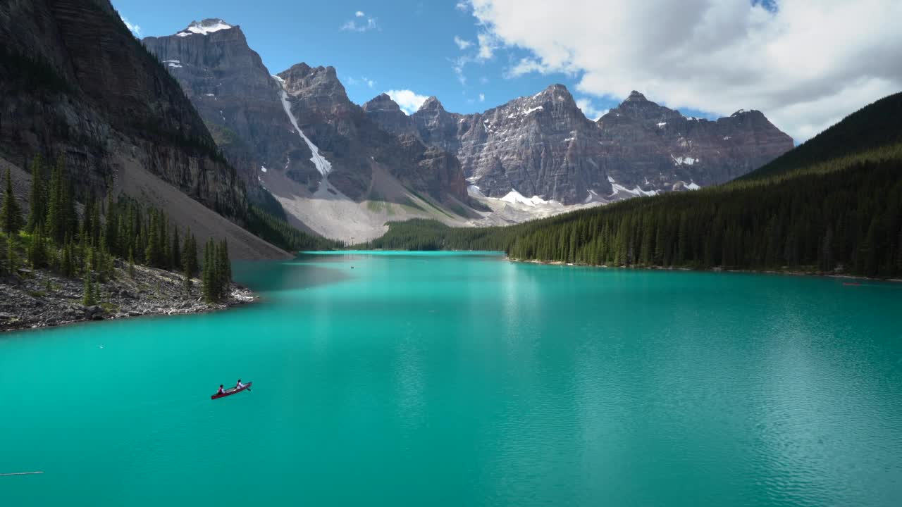 夏天在加拿大艾伯塔省班夫国家公园的冰碛湖上划独木舟的游客视频素材