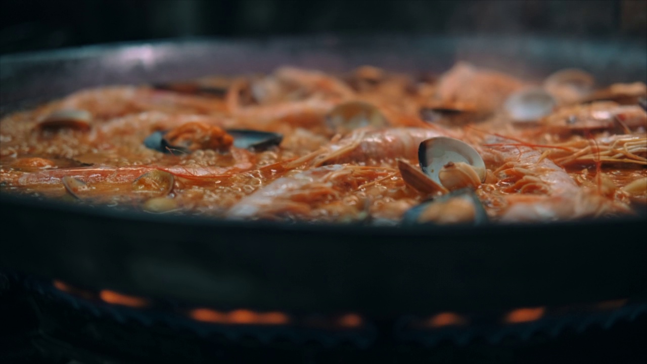 特写慢动作查看海鲜饭在煎锅上烹饪视频素材