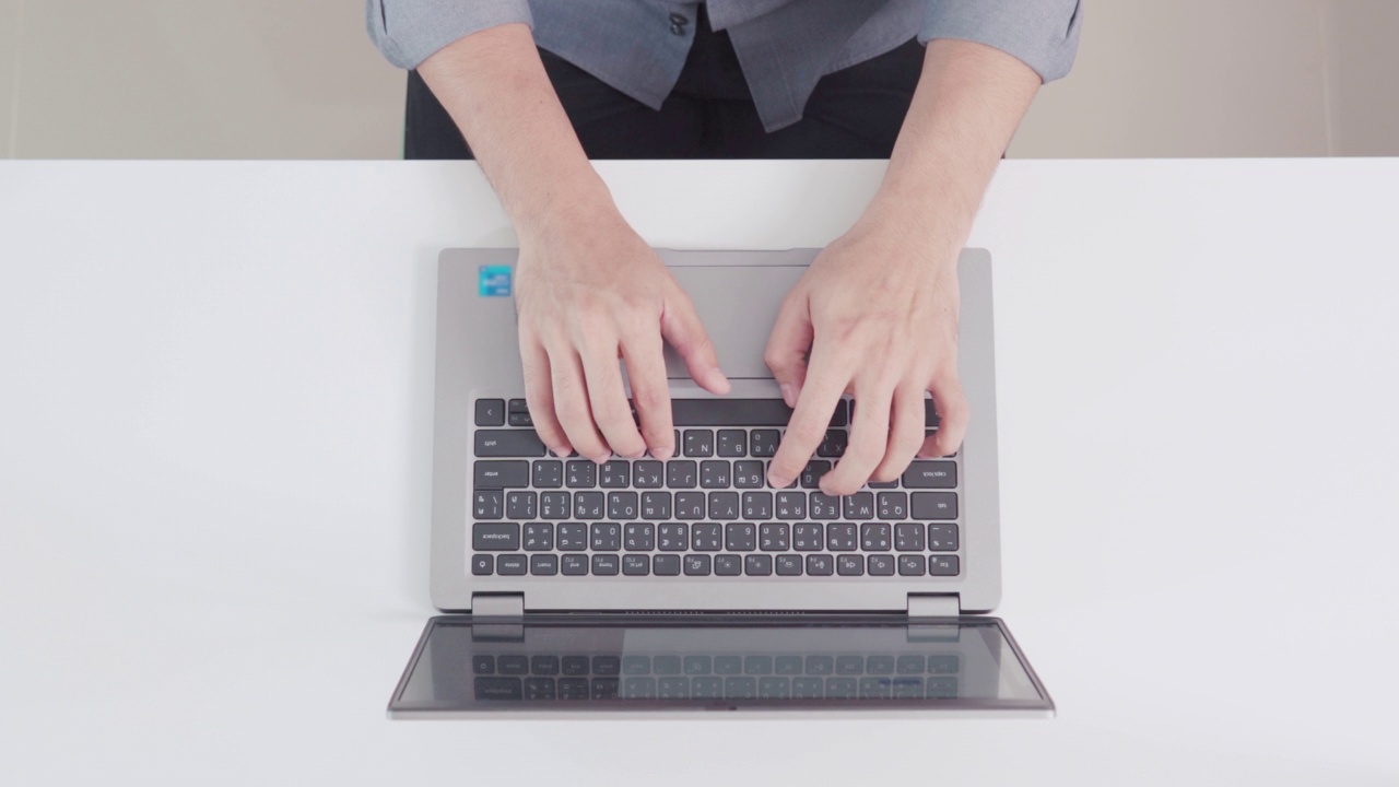 俯视图男子的手打字和工作与笔记本电脑在白色背景，有大量的空间复制或图形。视频素材