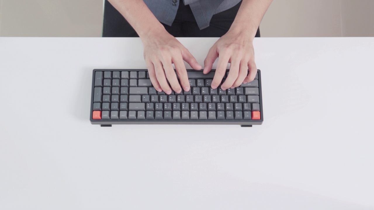 俯视图男子的手打字和工作与笔记本电脑在白色背景，有大量的空间复制或图形。视频素材