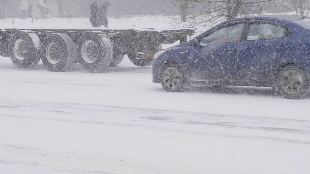 雪在城市的道路上与汽车。视频素材