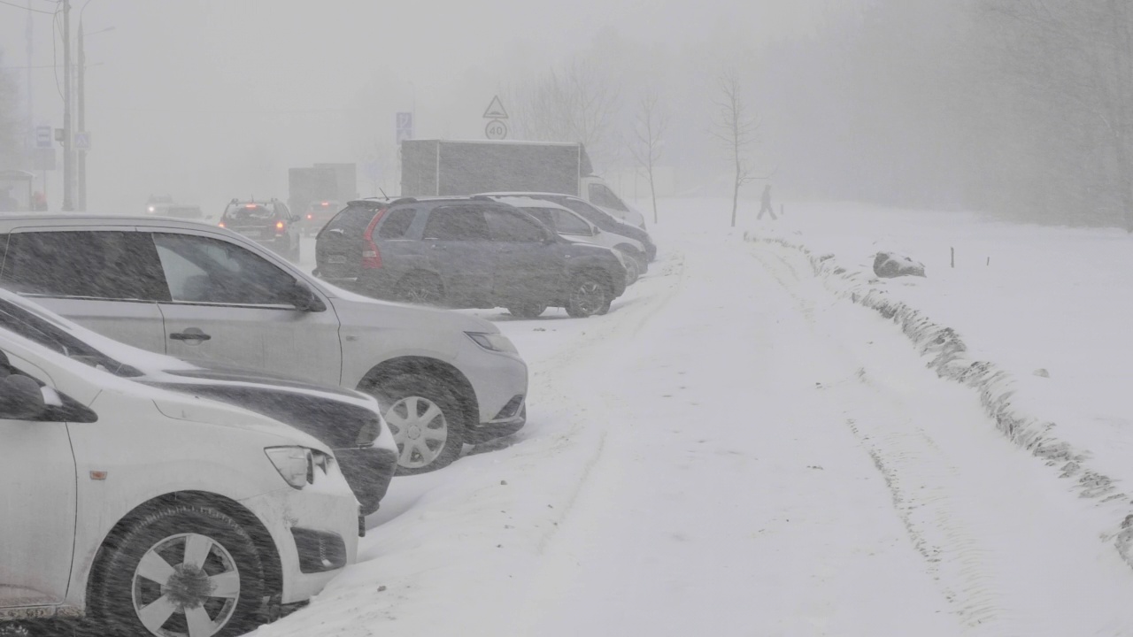 雪在城市的道路上与汽车。视频素材