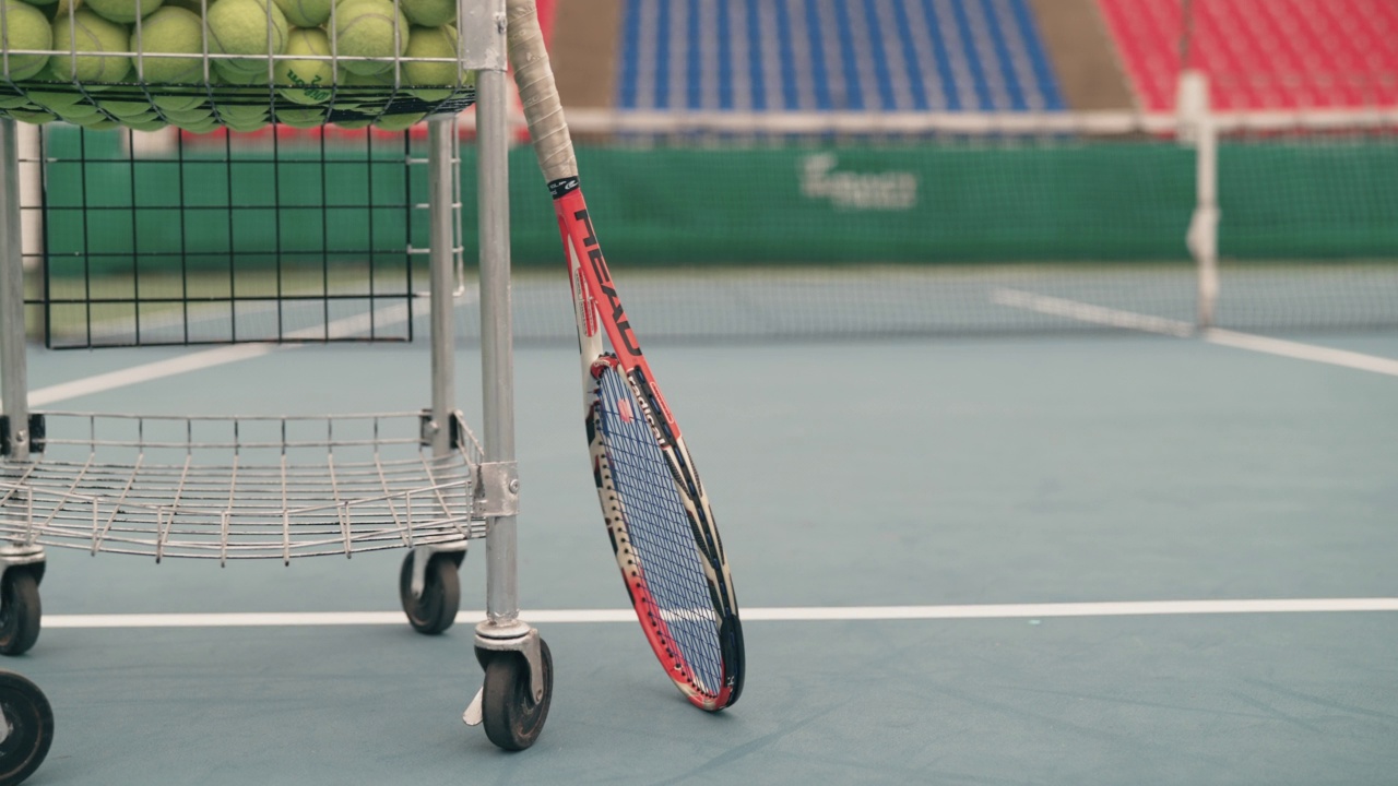 空的网球场，有网球车和球拍。视频下载