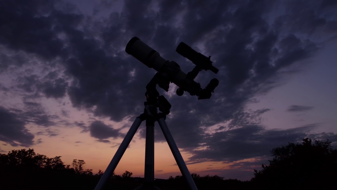 彩色天空下望远镜的剪影。视频素材