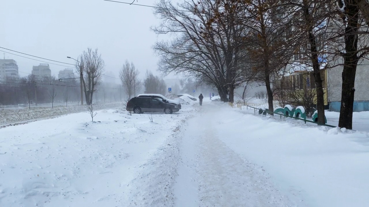 雪在城市的道路上与汽车一月视频下载
