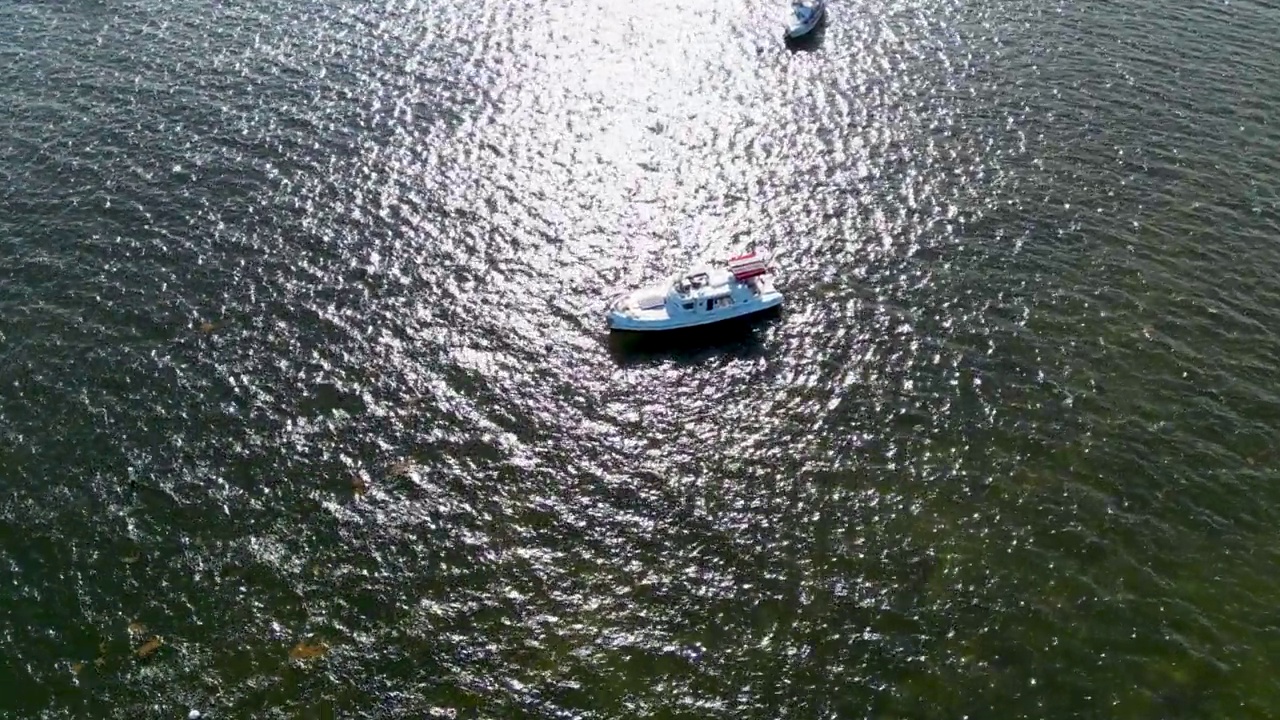 一个阳光明媚的日子，比斯坎湾的一艘帆船使用太阳能电池板的无人机轨道拍摄视频素材