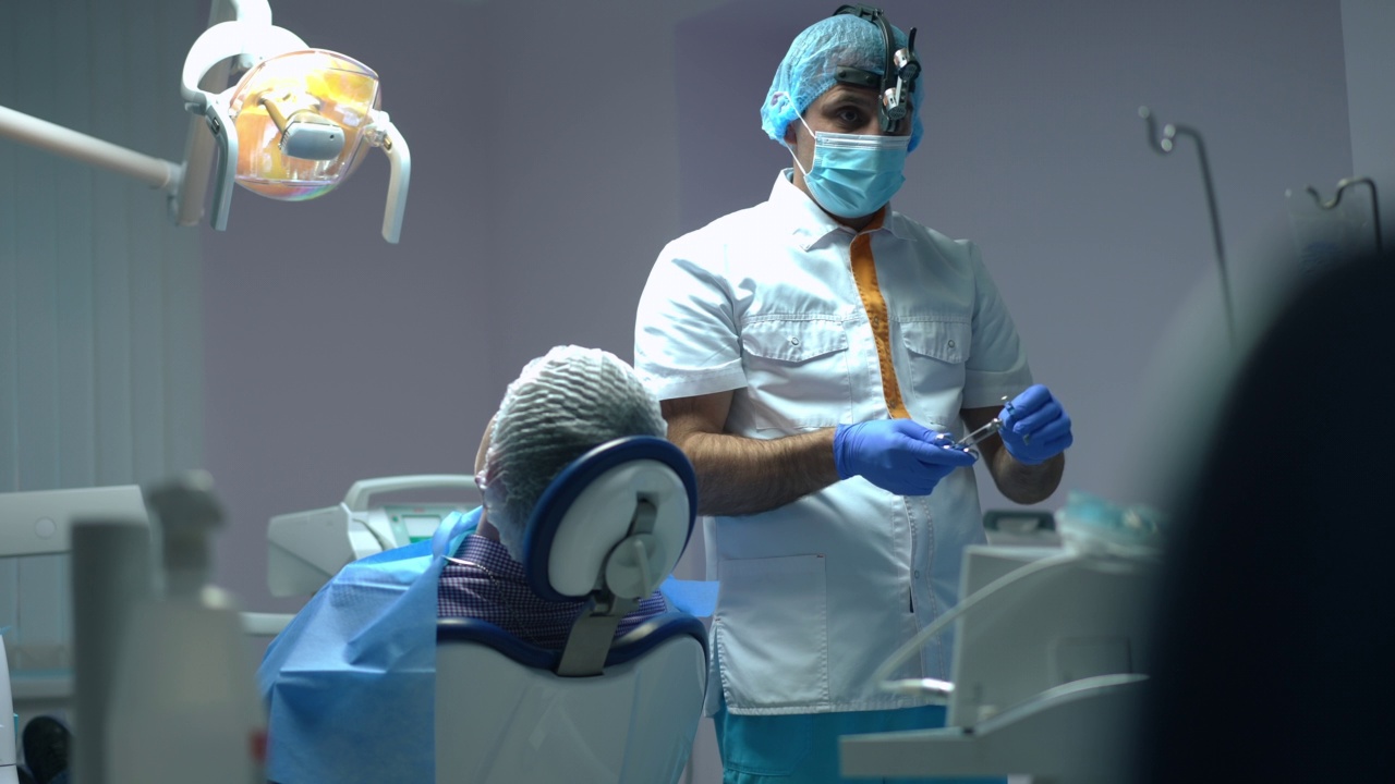 机架焦点从自信的中东牙医准备麻醉注射助手通过慢动作医疗工具。专业的医生和护士在医院准备治疗。视频素材