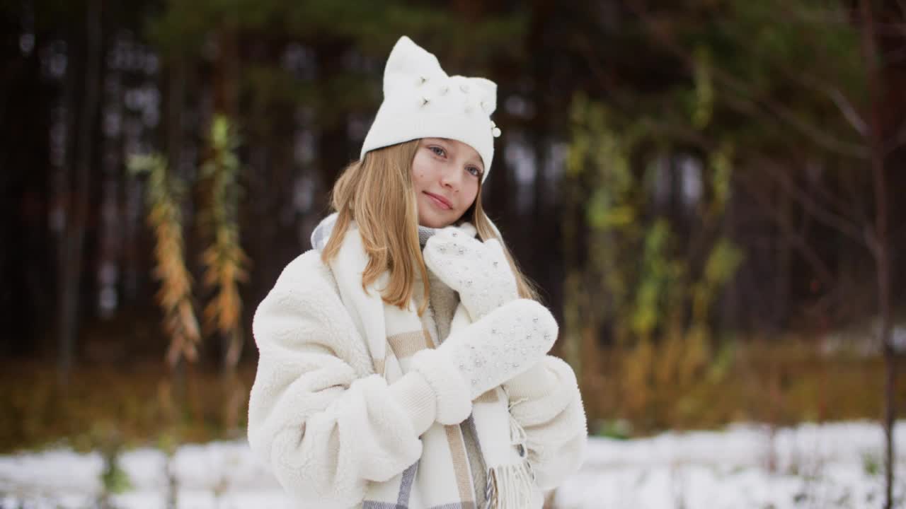 美丽的女孩在冬天戴着白色的手套，帽子和毛皮大衣视频素材
