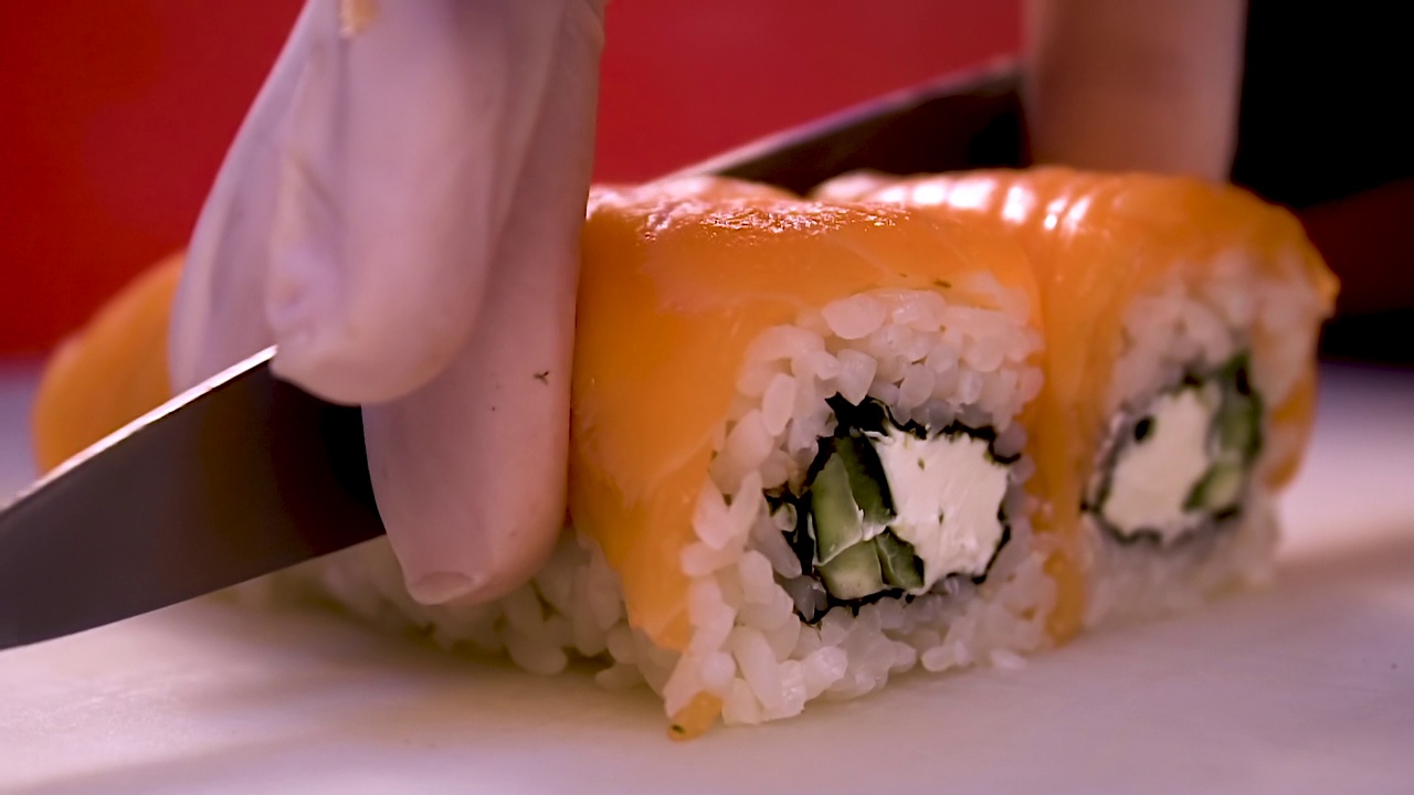 把面包卷切成片。用米饭和金枪鱼片做面包卷。传统日本料理中的一种寿司视频下载