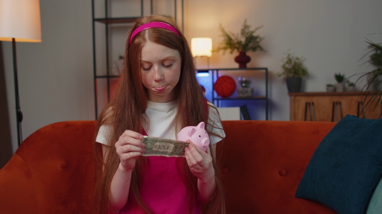 可怜的小女孩抱着储蓄罐和一元钞票，金融危机，破产，贫穷视频素材