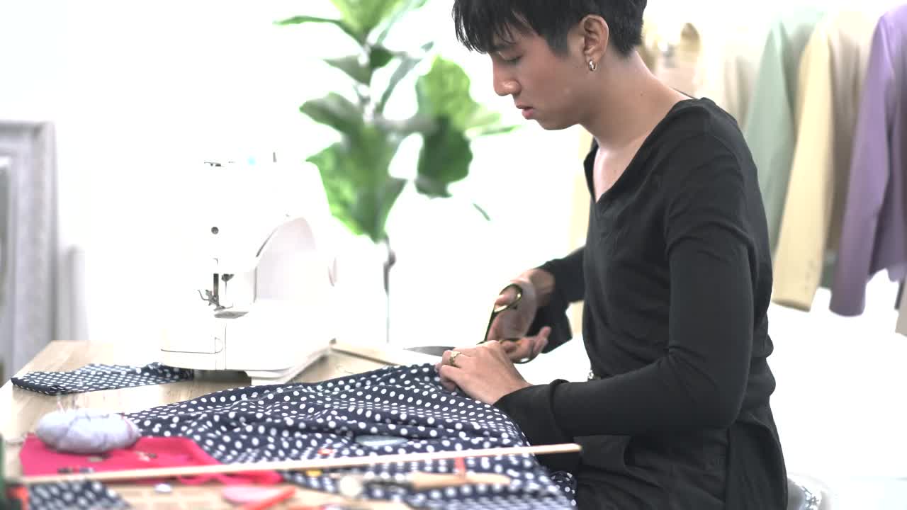 年轻的时装设计师剪裁一块充满活力的布从卷视频下载