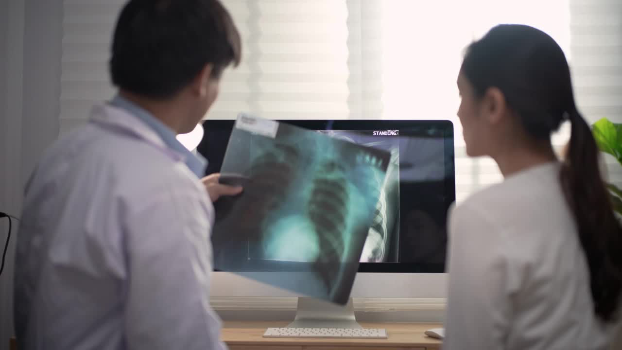 医生和病人一起检查x光片结果视频素材