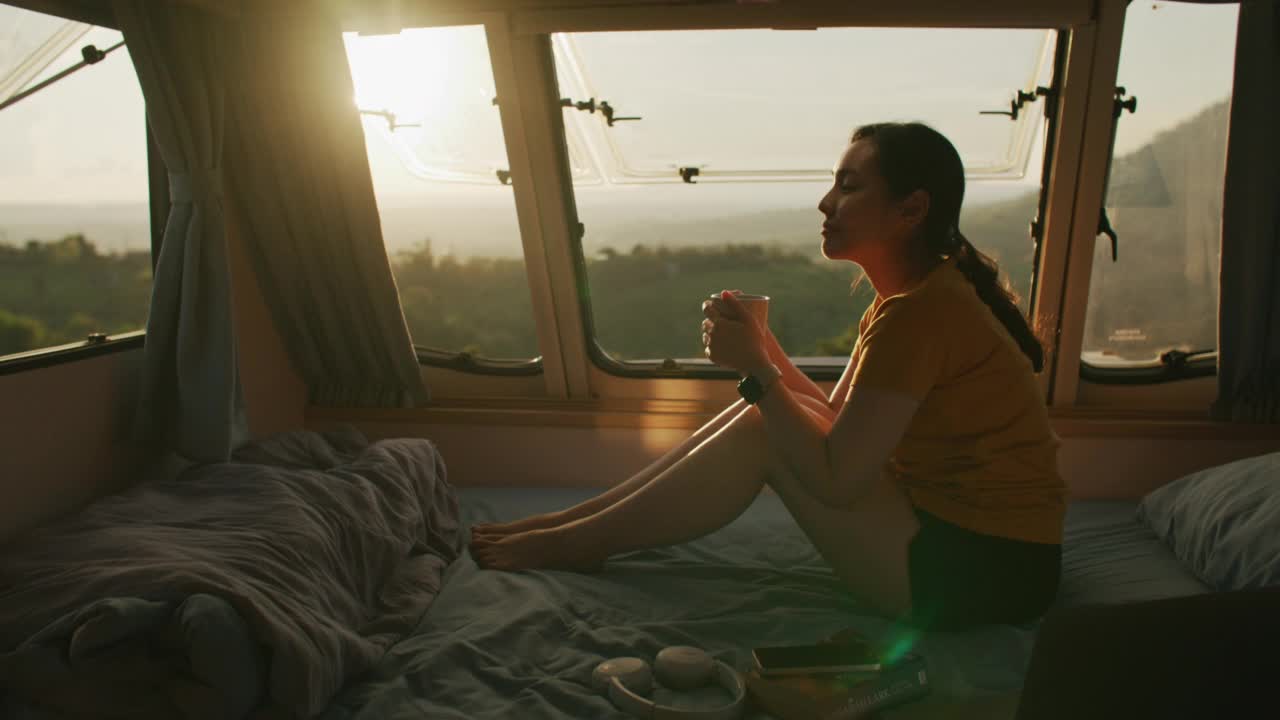 在露营车里看风景喝茶的女人视频素材