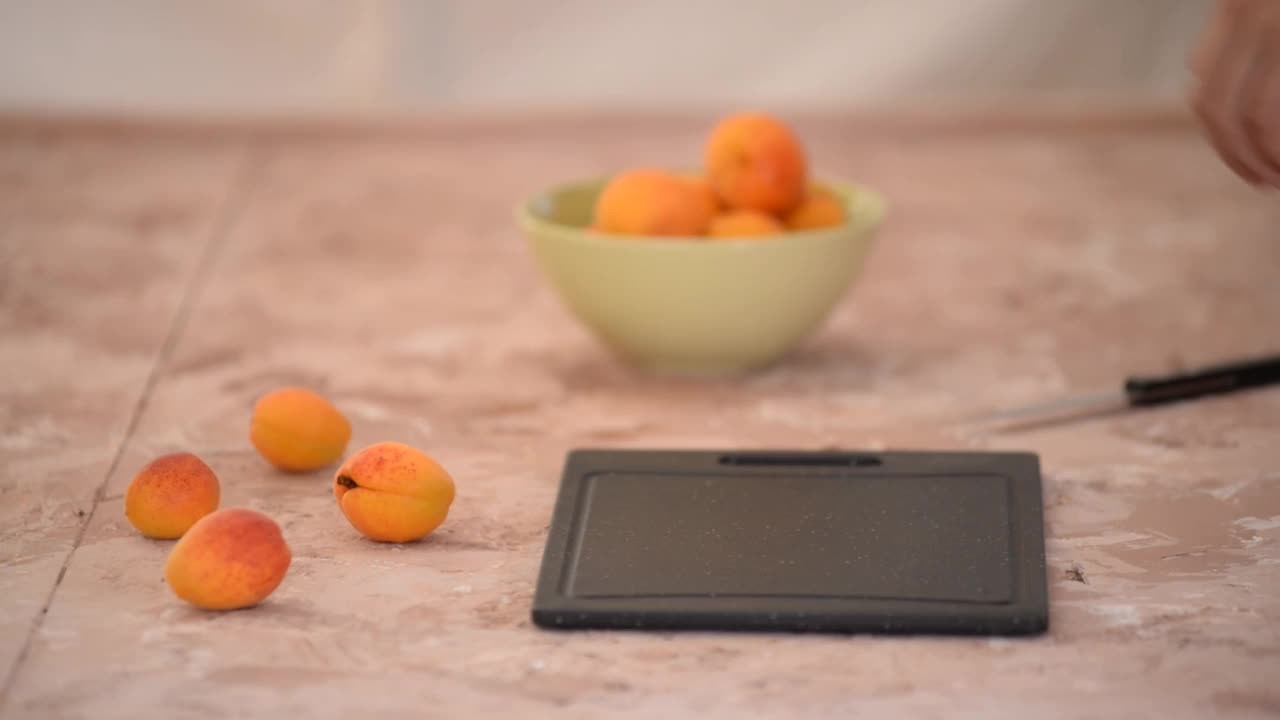 厨房里切甜鲜杏的女人。视频下载