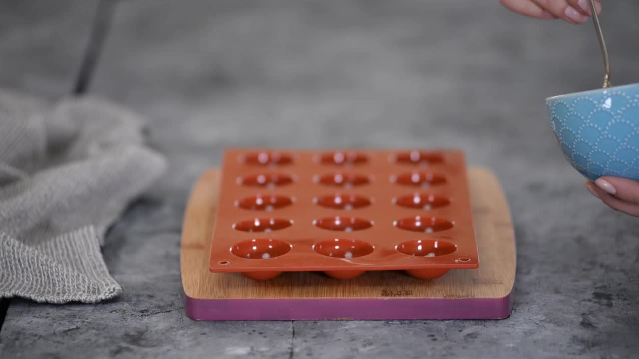 厨师将果仁酱倒入硅胶模具。视频下载