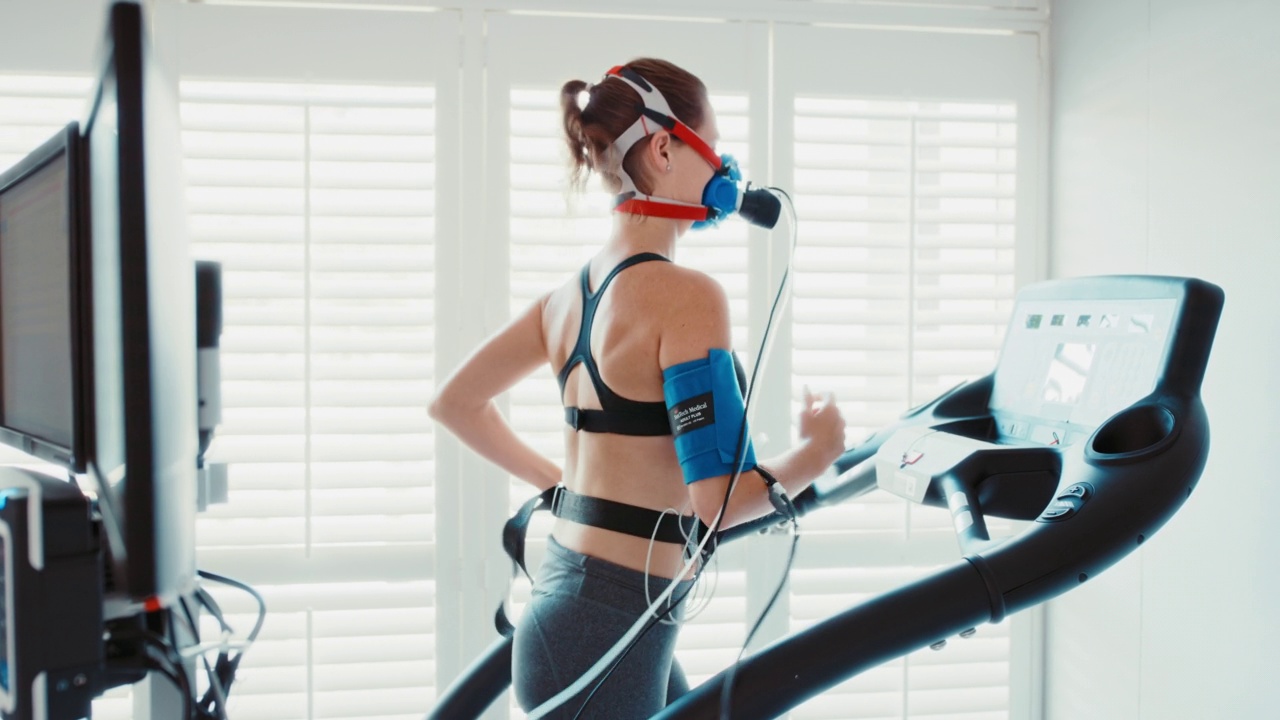 运动员在运动中心进行健康检查，在运动机上跑步，监测血压、呼吸和心率。显示医学耐力和性能测试结果的计算机视频下载