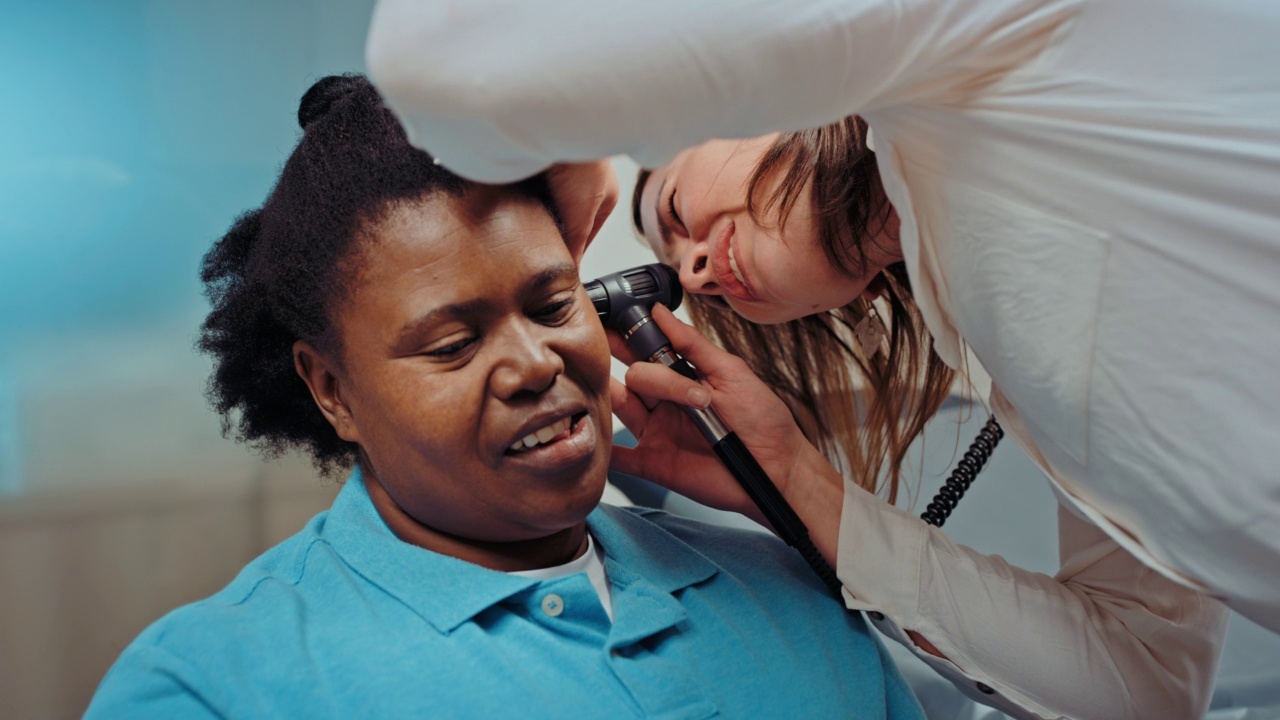 专业耳科医师、耳鼻喉科专家检查女性是否有眩晕、耳膜感染。耳鼻喉科医生利用耳镜工具检查残疾病人的耳朵，在医院门诊会诊视频下载