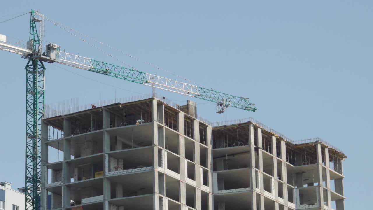 建造公寓楼。蓝天背景下的起重机和正在施工的建筑。视频素材