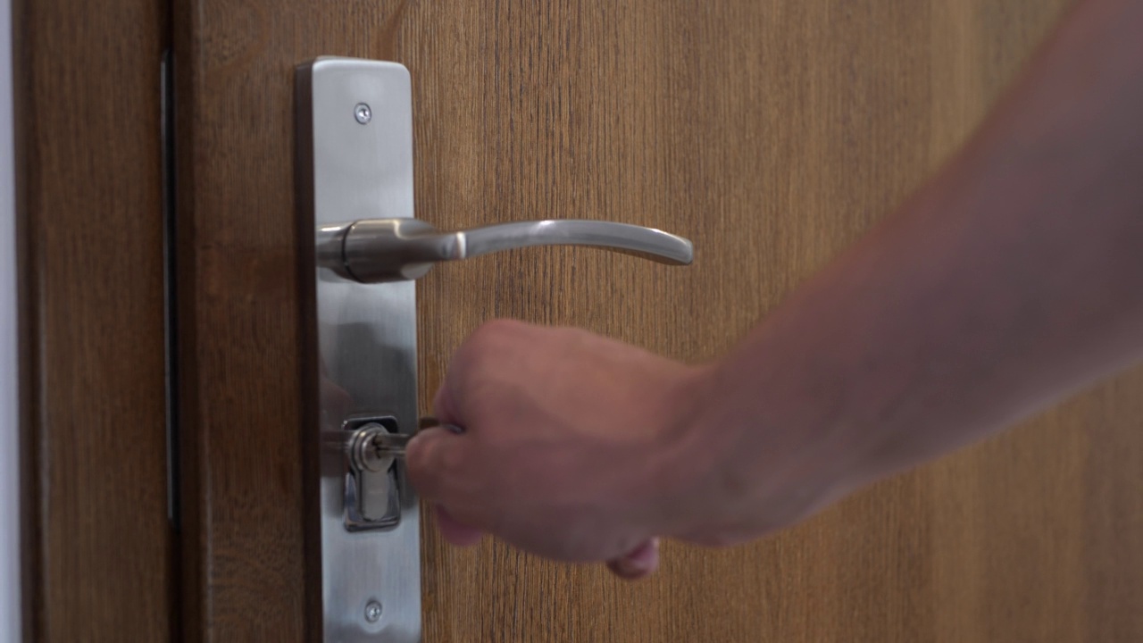 打开一扇锁着的木门。在锁里转动钥匙。视频下载