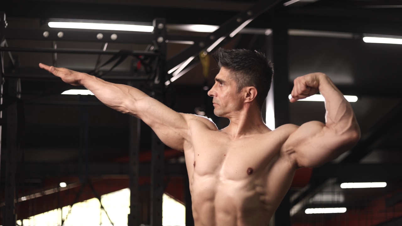 肌肉男在健身房展示健美运动员的姿势，健美视频素材