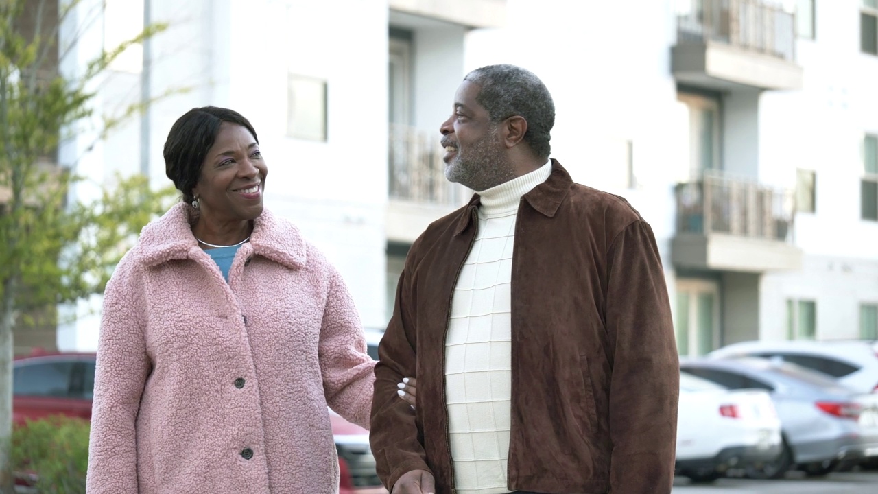 一对年长的非裔美国夫妇走在大楼外视频素材