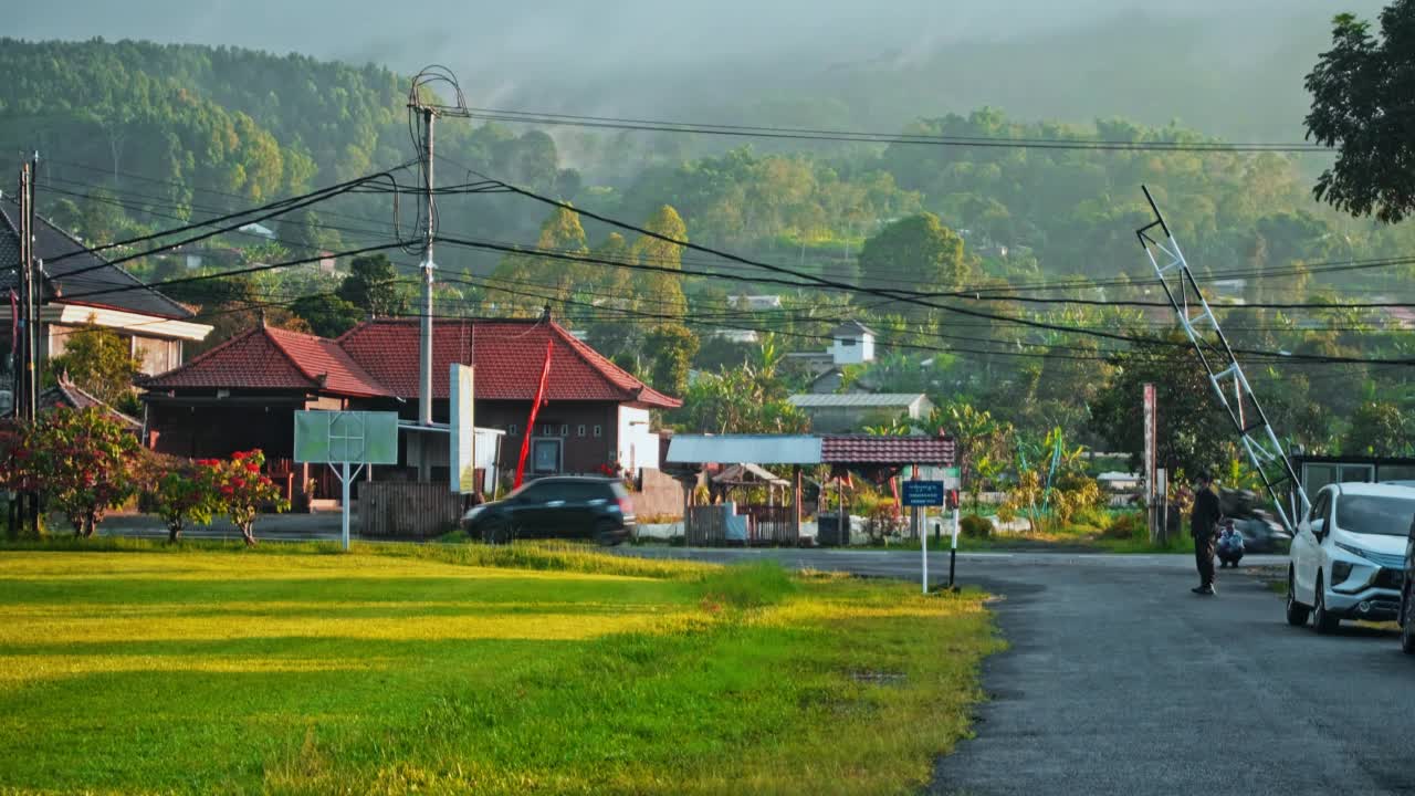 印度尼西亚街道，红色屋顶的ai房子，绿色的雨林和云的背景视频下载