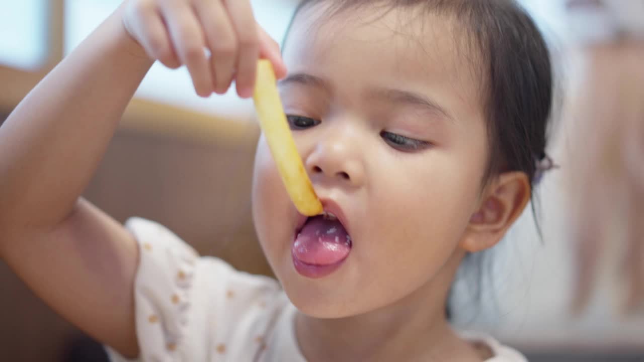亚洲小女孩喜欢吃薯条的特写视频素材