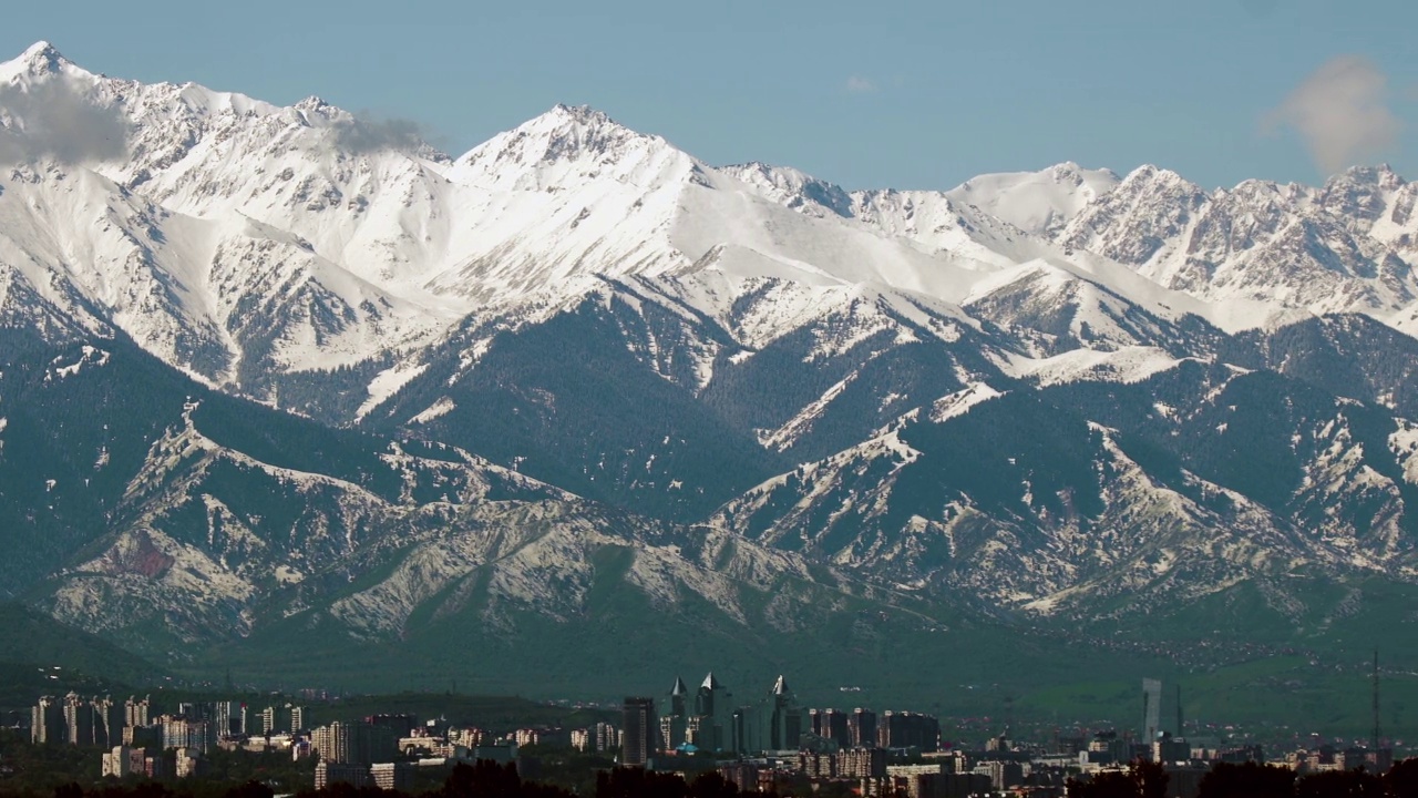 哈萨克斯坦阿拉木图雪山和城市的全景拍摄视频下载