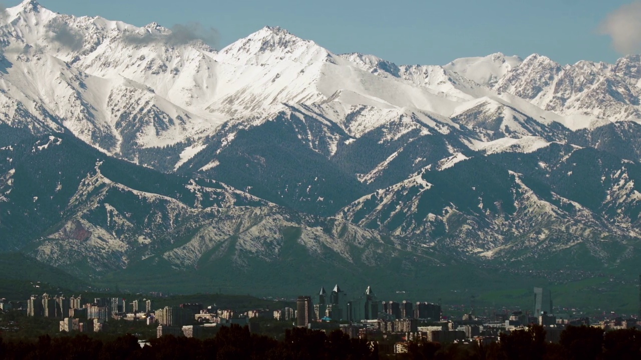 哈萨克斯坦阿拉木图美丽的雪山和城市全景拍摄视频下载