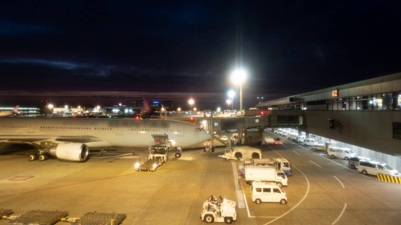 延时:货物车在黄昏时分将货物和行李搬运到机场的飞机上视频素材