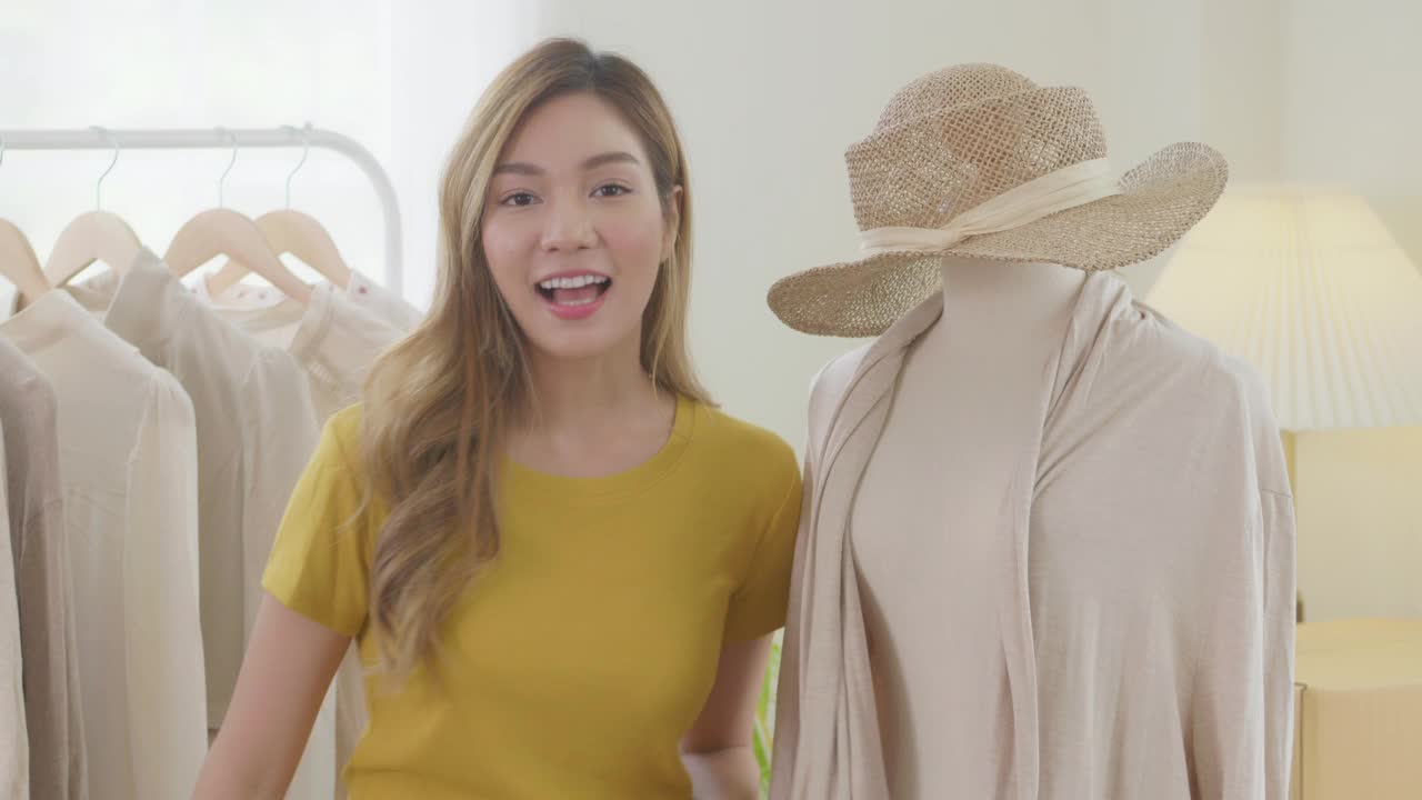 亚洲年轻女性通过Livestream在网上卖衣服，充满乐趣和快乐。视频下载