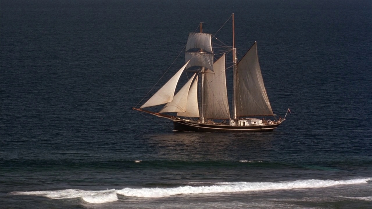 帆船从右向左靠近海岸航行的大角度视频素材