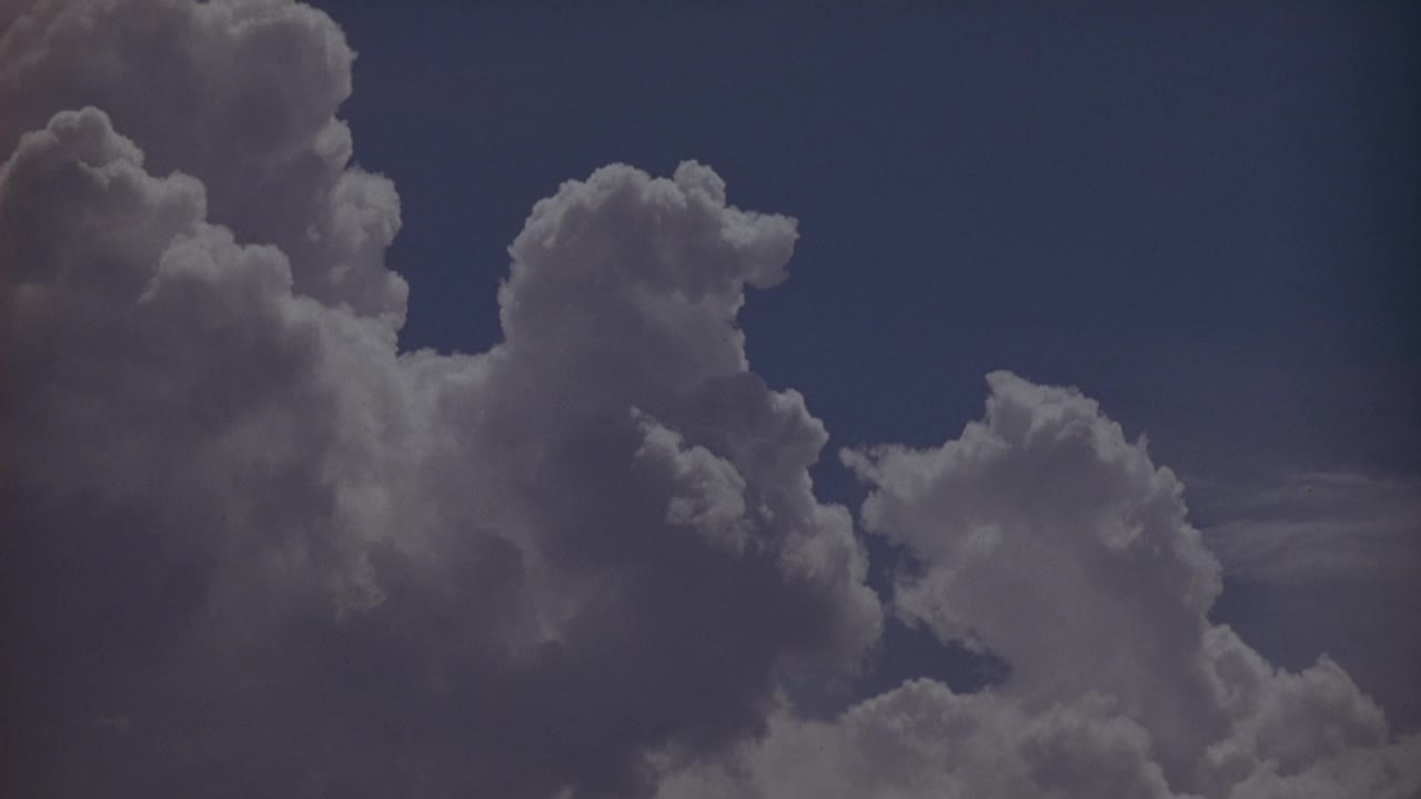 宽阔的角度白色和灰色的浮云在左边与蓝天背景视频素材