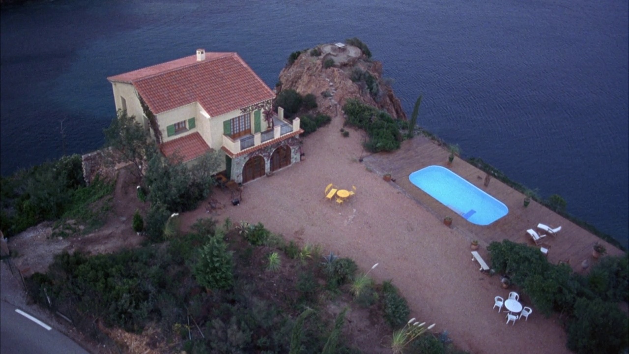 中角高角下的西班牙式两层别墅，带前院和游泳池的度假屋。房子靠海岸线靠悬崖，背景是海洋。酒喝完会摇晃。底片剪视频下载