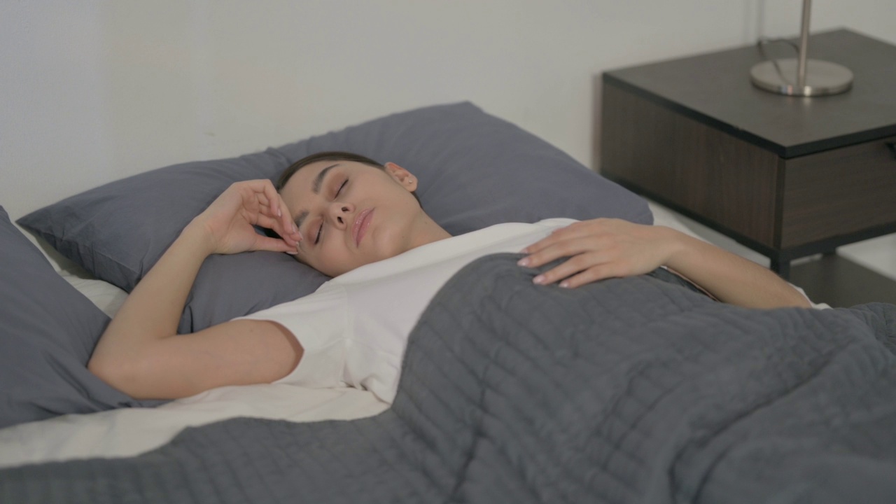 西班牙裔女性睡在床上感到不舒服视频素材