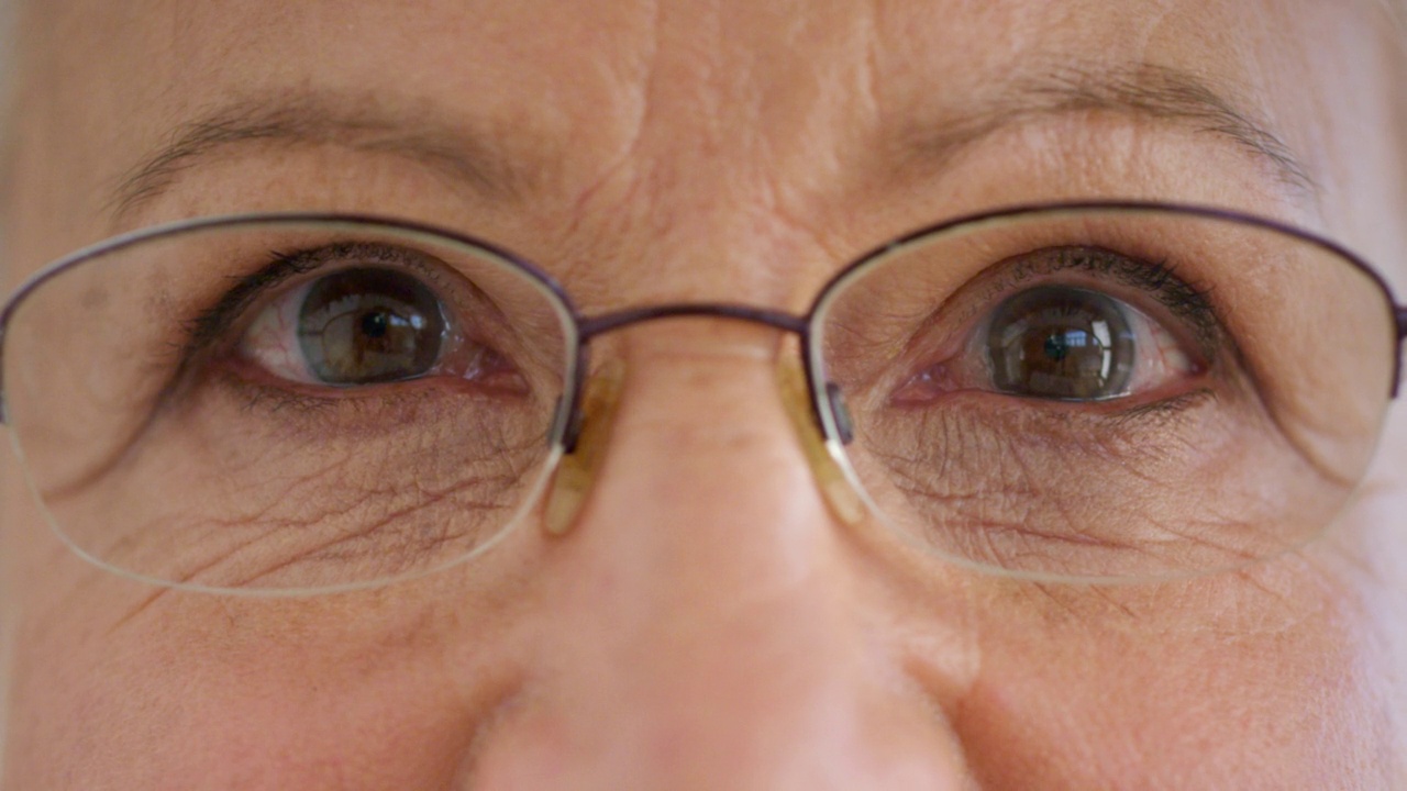 特写脸的高级妇女的眼睛与眼镜，以改善她的视力。肖像一位老妇人与眼镜帮助视力或近视。随着年龄的增长，一切都会变坏视频素材